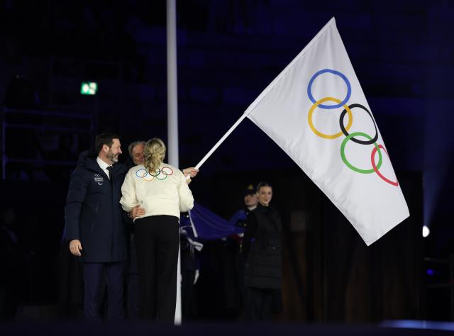 (260222) -- VERONA, Feb. 22, 2026 (Xinhua) -- This photo taken on Feb. 22, 2026 shows the handover of the Olympic flag during the closing ceremony of the Milan-Cortina 2026 Olympic Winter Games at Verona Olympic Arena in Verona, Italy. (Xinhua/Li Ming)