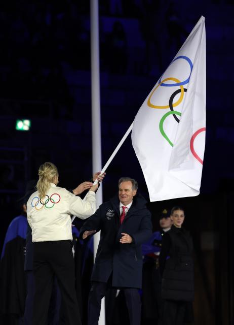 (260222) -- VERONA, Feb. 22, 2026 (Xinhua) -- This photo taken on Feb. 22, 2026 shows the handover of the Olympic flag during the closing ceremony of the Milan-Cortina 2026 Olympic Winter Games at Verona Olympic Arena in Verona, Italy. (Xinhua/Li Ming)