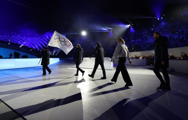 (260222) -- VERONA, Feb. 22, 2026 (Xinhua) -- This photo taken on Feb. 22, 2026 shows the handover of the Olympic flag during the closing ceremony of the Milan-Cortina 2026 Olympic Winter Games at Verona Olympic Arena in Verona, Italy. (Xinhua/Li Ming)