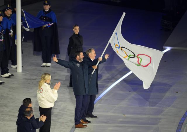 (260222) -- VERONA, Feb. 22, 2026 (Xinhua) -- President of the Provence-Alpes-Cote d'Azur Region Renaud Muselier and President of the Auvergne-Rhone-Alpes Region Fabrice Pannekoucke wave the Olympic flag during the closing ceremony of the Milan-Cortina 2026 Olympic Winter Games at Verona Olympic Arena in Verona, Italy, Feb. 22, 2026. (Xinhua/Xue Yuge)