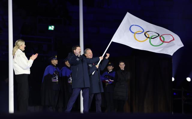 (260222) -- VERONA, Feb. 22, 2026 (Xinhua) -- President of the Provence-Alpes-Cote d'Azur Region Renaud Muselier and President of the Auvergne-Rhone-Alpes Region Fabrice Pannekoucke wave the Olympic flag during the closing ceremony of the Milan-Cortina 2026 Olympic Winter Games at Verona Olympic Arena in Verona, Italy, Feb. 22, 2026. (Xinhua/Li Ming)