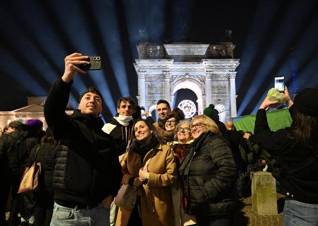 (260222) -- MILAN, Feb. 22, 2026 (Xinhua) -- People pose for photos in front of the cauldron of the Milan-Cortina 2026 Olympic Winter Games in Milan, Italy, Feb. 22, 2026. (Xinhua/Wu Wei)