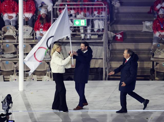 (260222) -- VERONA, Feb. 22, 2026 (Xinhua) -- This photo taken on Feb. 22, 2026 shows the handover of the Olympic flag during the closing ceremony of the Milan-Cortina 2026 Olympic Winter Games at Verona Olympic Arena in Verona, Italy. (Xinhua/Li Jing)