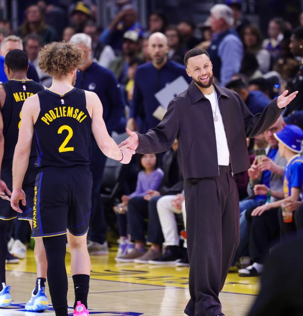 (260223) -- SAN FRANCISCO, Feb. 23, 2026 (Xinhua) -- Brandin Podziemski (L) of Golden State Warriors interacts with teammate Stephen Curry during the 2025-2026 NBA regular season game between Golden State Warriors and Denver Nuggets in San Francisco, the United States, Feb. 22, 2026. (Photo by Arthur Dong/Xinhua)