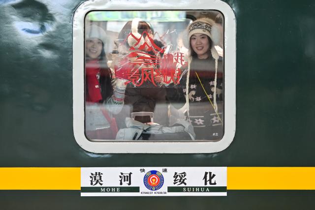 (260223) -- BEIJING, Feb. 23, 2026 (Xinhua) -- Passengers board a train at Harbin Railway Station in Harbin, northeast China's Heilongjiang Province, Feb. 22, 2026. China's 2026 Spring Festival travel rush had passed its halfway point as of Saturday, with inter-regional passenger trips reaching 5.08 billion in the first 20 days, the Ministry of Transport said on Sunday. (Photo by Yuan Yong/Xinhua)