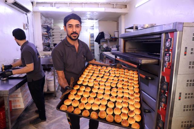 (260223) -- BAGHDAD, Feb. 23, 2026 (Xinhua) -- A worker shows traditional sweets during the holy month of Ramadan in Baghdad, Iraq, on Feb. 23, 2026. (Xinhua/Khalil Dawood)