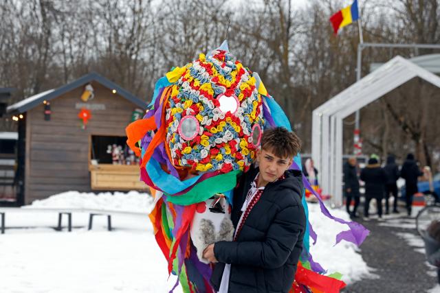 (260223) -- BRANESTI, Feb. 23, 2026 (Xinhua) -- A man carries his mask during the annual "Cuckoo's Day" (Ziua Cucilor) festival in Branesti, near Bucharest, capital of Romania, on Feb. 23, 2026. Groups of masked people took part in the traditional festival, singing and dancing for good health and fertility at the beginning of spring. (Photo by Cristian Cristel/Xinhua)