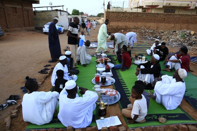 (260223) -- OMDURMAN, Feb. 23, 2026 (Xinhua) -- Photo taken on Feb. 23, 2026 shows residents sitting on mats waiting for the Maghrib call to prayer to break their fast, at Al-Hattana neighborhood of Omdurman, north of the Sudanese capital Khartoum. (Photo by Mohamed Khidir/ Xinhua)
