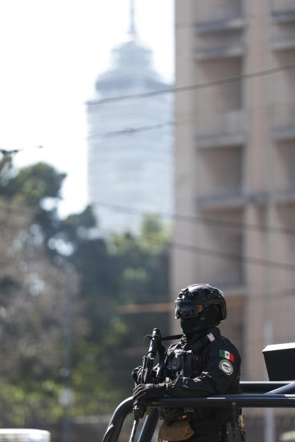 (260223) -- MEXICO CITY, Feb. 23, 2026 (Xinhua) -- Security personnel guard on a street in Mexico City, Mexico, Feb. 23, 2026. Retaliation attacks from the Jalisco New Generation Cartel have left 27 security personnel dead, Mexico's Secretary of Security and Citizen Protection Omar Garcia Harfuch said Monday at a press conference. Mexican military forces launched an operation on Sunday and killed the Jalisco New Generation Cartel leader Nemesio Oseguera Cervantes, alias "El Mencho." Members of cartels have set fire to cars and commercial facilities, and blocked roads. Some states closed schools on Monday. (Photo by Francisco Canedo/Xinhua)