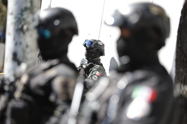 (260223) -- MEXICO CITY, Feb. 23, 2026 (Xinhua) -- Security personnel guard on a street in Mexico City, Mexico, Feb. 23, 2026. Retaliation attacks from the Jalisco New Generation Cartel have left 27 security personnel dead, Mexico's Secretary of Security and Citizen Protection Omar Garcia Harfuch said Monday at a press conference. Mexican military forces launched an operation on Sunday and killed the Jalisco New Generation Cartel leader Nemesio Oseguera Cervantes, alias "El Mencho." Members of cartels have set fire to cars and commercial facilities, and blocked roads. Some states closed schools on Monday. (Photo by Francisco Canedo/Xinhua)