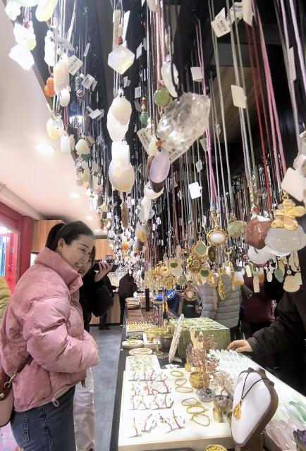 (260224) -- BEIJING, Feb. 24, 2026 (Xinhua) -- Tourists buy souvenirs at the Nanluoguxiang Lane in Beijing, capital of China, Feb. 24, 2026. (Xinhua/Li Xin)
