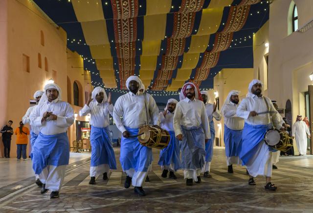 (260224) -- DOHA, Feb. 24, 2026 (Xinhua) -- Traditional Ramadan Musaharati performers perform at the Old Doha Port during the holy month of Ramadan in Doha, Qatar, on Feb. 23, 2026. The Musaharati tradition involves drummers touring neighborhoods at night to wake up the residents for the pre-dawn "suhoor" meal. (Photo by Nikku/Xinhua)