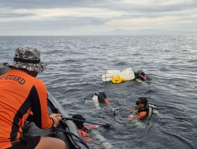 (260224) -- BASILAN, Feb. 24, 2026 (Xinhua) -- The Philippine Coast Guard (PCG) divers work in the waters near Baluk-Baluk Island in Basilan, the Philippines, Feb. 22, 2026. The PCG on Tuesday said it has completed a full underwater search of passenger ferry MV Trisha Kerstin 3, which sank off Basilan province on Jan. 26, leaving at least 65 people dead. (PCG/Handout via Xinhua)