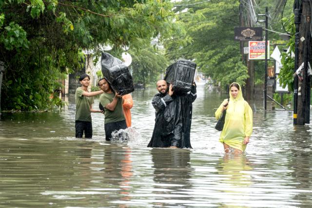 (260224) -- BALI, Feb. 24, 2026 (Xinhua) -- Tourists are evacuated among flooding in Badung Regency, Bali Province of Indonesia, Feb. 24, 2026. Heavy rainfall has triggered severe flooding in parts of Indonesia's resort island of Bali, inundating areas of Denpasar, particularly the Sanur area, and prompting the evacuation of dozens of foreign visitors, according to local authorities on Tuesday. (Photo by Dicky Bisinglasi/Xinhua)