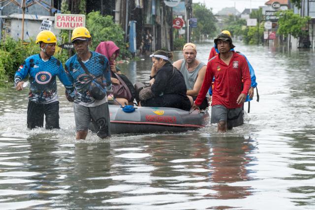 (260224) -- BALI, Feb. 24, 2026 (Xinhua) -- Tourists are evacuated among flooding in Badung Regency, Bali Province of Indonesia, Feb. 24, 2026. Heavy rainfall has triggered severe flooding in parts of Indonesia's resort island of Bali, inundating areas of Denpasar, particularly the Sanur area, and prompting the evacuation of dozens of foreign visitors, according to local authorities on Tuesday. (Photo by Dicky Bisinglasi/Xinhua)