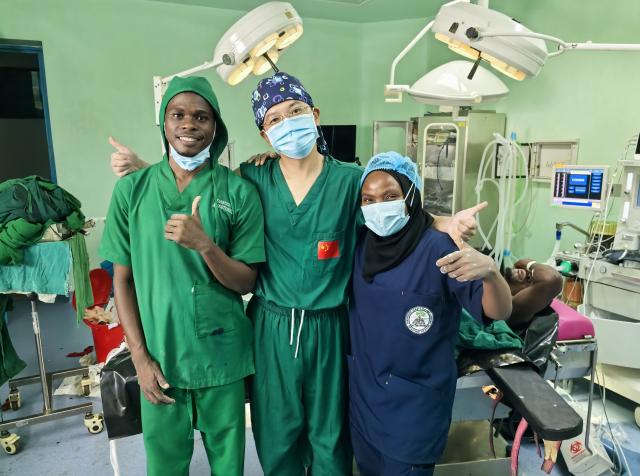 (260224) -- ZANZIBAR, Feb. 24, 2026 (Xinhua) -- Hou Jianwen (C) and his local colleagues pose for a group photo after completing the surgery in Zanzibar, Tanzania, on Jan. 18, 2026. TO GO WITH "Feature: Chinese surgeons save Tanzanian conductor's fractured arm, restoring hope for family" (The 35th Chinese medical team in Zanzibar/Handout via Xinhua)