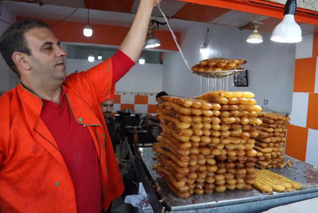 (260225) -- BOUFARIK, Feb. 25, 2026 (Xinhua) -- A man makes traditional dessert known as Zalabia which is popular during Ramadan, in Boufarik, Algeria, Feb. 24, 2026. (Xinhua)