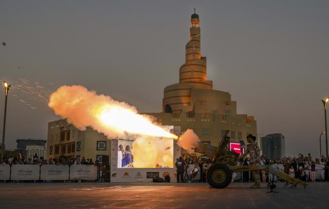 (260225) -- DOHA, Feb. 25, 2026 (Xinhua) -- A Qatari guard fires an Iftar cannon to mark the breaking of fast during Ramadan at Souq Waqif in Doha, Qatar, on Feb. 24, 2026. The Iftar cannon is fired on a daily basis during the holy month of Ramadan to notify people the time of Iftar. (Photo by Nikku/Xinhua)