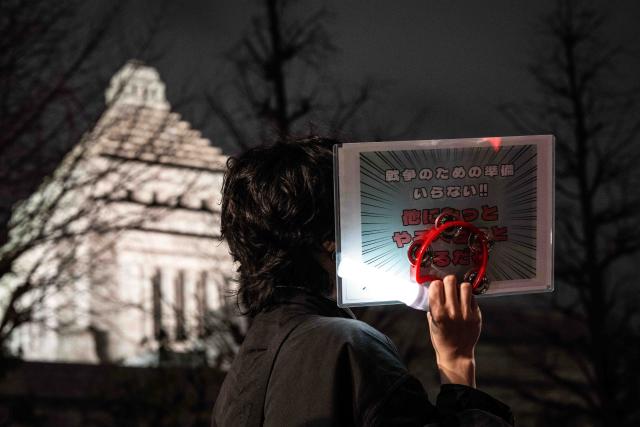 (260225) -- TOKYO, Feb. 25, 2026 (Xinhua) -- A person holding a sign attends a rally in front of the Second Members' Office Building of the House of Representatives in Tokyo, Japan, Feb. 24, 2026. A large crowd of Japanese people gathered Tuesday evening in Tokyo to protest Prime Minister Sanae Takaichi's dangerous push for policies including accelerating constitutional revision, expanding military capabilities and strengthening national intelligence functions, voicing concerns about the country's future direction. (Xinhua/Jia Haocheng)
