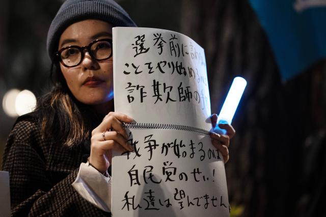 (260225) -- TOKYO, Feb. 25, 2026 (Xinhua) -- A woman holding a sign attends a rally in front of the Second Members' Office Building of the House of Representatives in Tokyo, Japan, Feb. 24, 2026. A large crowd of Japanese people gathered Tuesday evening in Tokyo to protest Prime Minister Sanae Takaichi's dangerous push for policies including accelerating constitutional revision, expanding military capabilities and strengthening national intelligence functions, voicing concerns about the country's future direction. (Xinhua/Jia Haocheng)