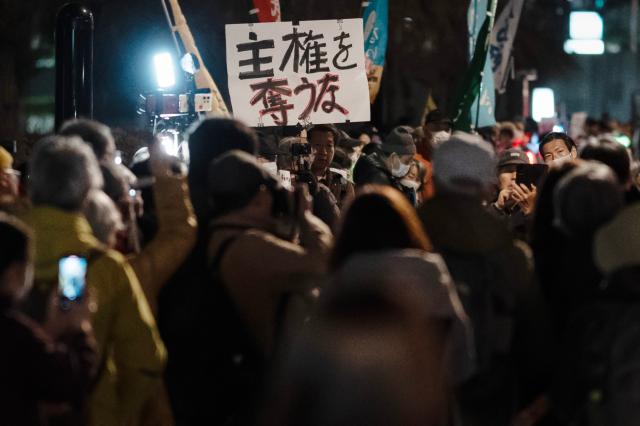 (260225) -- TOKYO, Feb. 25, 2026 (Xinhua) -- People attend a rally in front of the Second Members' Office Building of the House of Representatives in Tokyo, Japan, Feb. 24, 2026. A large crowd of Japanese people gathered Tuesday evening in Tokyo to protest Prime Minister Sanae Takaichi's dangerous push for policies including accelerating constitutional revision, expanding military capabilities and strengthening national intelligence functions, voicing concerns about the country's future direction. (Xinhua/Jia Haocheng)