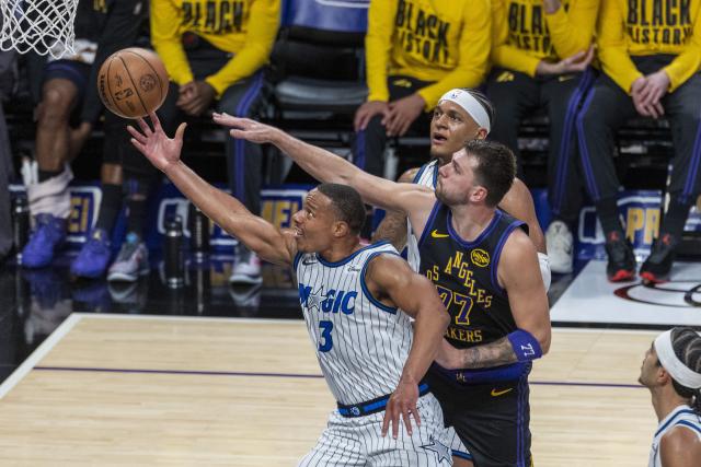 (260225) -- LOS ANGELES, Feb. 25, 2026 (Xinhua) -- Orlando Magic's Desmond Bane (front) goes past Los Angeles Lakers' Luka Doncic (C) to the basket during the 2025-2026 NBA regular season basketball game between Los Angeles Lakers and Orlando Magic in Los Angeles, the United States, Feb. 24, 2026. (Photo by Ringo Chiu/Xinhua)