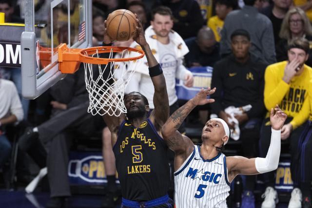 (260225) -- LOS ANGELES, Feb. 25, 2026 (Xinhua) -- Los Angeles Lakers' Deandre Ayton (L) dunks against Orlando Magic's Paolo Banchero during the 2025-2026 NBA regular season basketball game between Los Angeles Lakers and Orlando Magic in Los Angeles, the United States, Feb. 24, 2026. (Photo by Ringo Chiu/Xinhua)