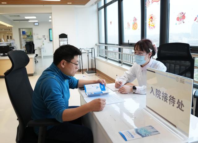 (260227) -- SHANGHAI, Feb. 27, 2026 (Xinhua) -- A nurse (R) explains the "companion-free" care services to a family member of an inpatient at a hospital in Shanghai, east China, Feb. 26, 2026. China's hospitals are piloting "companion-free" care services to ease the heavy burden of daily care-giving on the inpatients' families.
  The new mode of operation requires hosting hospitals to directly employ trained nursing assistants to provide 24-hour non-medical care for inpatients with particular needs. 
   Such services used to rely solely on family members of the inpatients or private caregivers they hire. (Xinhua/Liu Ying)