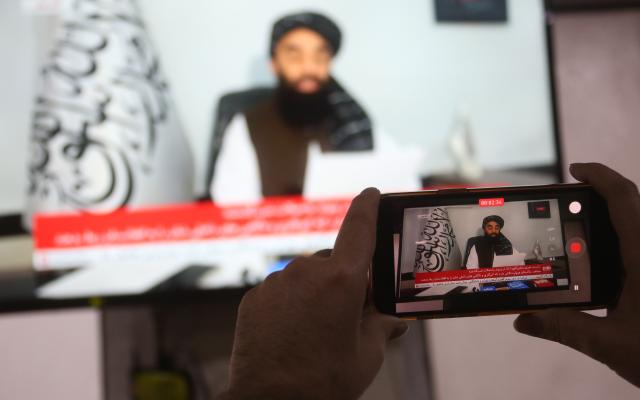 (260227) -- KABUL, Feb. 27, 2026 (Xinhua) -- This photo taken on Feb. 27, 2026 shows a television broadcasting Zabihullah Mujahid, spokesman for the Afghan government, addressing a press conference. Zabihullah Mujahid, spokesman for the Afghan government, said on Friday during a press conference on border tensions that the government has consistently emphasized peaceful solutions and continues to advocate for a constructive, non-violent approach to resolving the situation.
TO GO WITH "Afghanistan calls for non-violent resolution amid border clashes with Pakistan" (Photo by Saifurahman Safi/Xinhua)