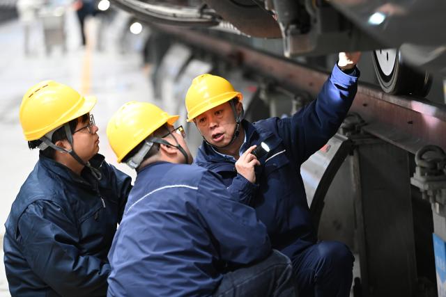(260227) -- XI'AN, Feb. 27, 2026 (Xinhua) -- Dong Hongtao (R) and colleagues examine and maintain a bullet train at a maintenance depot of China Railway Xi'an Group Co., Ltd. in Xi'an, northwest China's Shaanxi Province, Jan. 14, 2026.
  Dong Hongtao is a bullet train technician of China Railway Xi'an Group Co., Ltd. and a deputy to the National People's Congress (NPC). Since engaging in electric multiple unit (EMU) maintenance work in 2007, Dong has led his team to maintain over 120,000 EMU sets and handled more than 3,000 faults. He has been granted three national invention patents and 31 utility model patents. Dong has also been dedicated to the passing-on of technical skills, cultivating skilled talents for the industry through the national-level master technician studio led by him.
   As a senior technician who started as an ordinary worker, Dong understands the challenges faced by frontline workers in their developments. He has observed that they often have abundant practical experiences but lack theoretical knowledge. In response, he actively participates in initiatives to improve their skills and identifies young talents to foster their creativity.
   For this year's legislative session, Dong said he will continue to focus on the development of the skilled workforce, concentrating on advancing the implementation of the new professional title system, which features eight technical titles -- three more than the previous five-tier system. (Xinhua/Li Yibo)