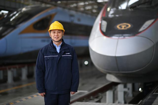 (260227) -- XI'AN, Feb. 27, 2026 (Xinhua) -- Dong Hongtao poses for a photo at a maintenance depot of China Railway Xi'an Group Co., Ltd. in Xi'an, northwest China's Shaanxi Province, Jan. 14, 2026.
  Dong Hongtao is a bullet train technician of China Railway Xi'an Group Co., Ltd. and a deputy to the National People's Congress (NPC). Since engaging in electric multiple unit (EMU) maintenance work in 2007, Dong has led his team to maintain over 120,000 EMU sets and handled more than 3,000 faults. He has been granted three national invention patents and 31 utility model patents. Dong has also been dedicated to the passing-on of technical skills, cultivating skilled talents for the industry through the national-level master technician studio led by him.
   As a senior technician who started as an ordinary worker, Dong understands the challenges faced by frontline workers in their developments. He has observed that they often have abundant practical experiences but lack theoretical knowledge. In response, he actively participates in initiatives to improve their skills and identifies young talents to foster their creativity.
   For this year's legislative session, Dong said he will continue to focus on the development of the skilled workforce, concentrating on advancing the implementation of the new professional title system, which features eight technical titles -- three more than the previous five-tier system. (Xinhua/Li Yibo)