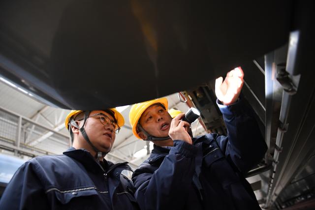 (260227) -- XI'AN, Feb. 27, 2026 (Xinhua) -- Dong Hongtao (R) and a colleague examine and maintain a bullet train at a maintenance depot of China Railway Xi'an Group Co., Ltd. in Xi'an, northwest China's Shaanxi Province, Jan. 14, 2026.
  Dong Hongtao is a bullet train technician of China Railway Xi'an Group Co., Ltd. and a deputy to the National People's Congress (NPC). Since engaging in electric multiple unit (EMU) maintenance work in 2007, Dong has led his team to maintain over 120,000 EMU sets and handled more than 3,000 faults. He has been granted three national invention patents and 31 utility model patents. Dong has also been dedicated to the passing-on of technical skills, cultivating skilled talents for the industry through the national-level master technician studio led by him.
   As a senior technician who started as an ordinary worker, Dong understands the challenges faced by frontline workers in their developments. He has observed that they often have abundant practical experiences but lack theoretical knowledge. In response, he actively participates in initiatives to improve their skills and identifies young talents to foster their creativity.
   For this year's legislative session, Dong said he will continue to focus on the development of the skilled workforce, concentrating on advancing the implementation of the new professional title system, which features eight technical titles -- three more than the previous five-tier system. (Xinhua/Li Yibo)