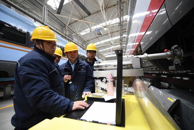 (260227) -- XI'AN, Feb. 27, 2026 (Xinhua) -- Dong Hongtao (2nd R) communicates with colleagues at a maintenance depot of China Railway Xi'an Group Co., Ltd. in Xi'an, northwest China's Shaanxi Province, Jan. 14, 2026.
  Dong Hongtao is a bullet train technician of China Railway Xi'an Group Co., Ltd. and a deputy to the National People's Congress (NPC). Since engaging in electric multiple unit (EMU) maintenance work in 2007, Dong has led his team to maintain over 120,000 EMU sets and handled more than 3,000 faults. He has been granted three national invention patents and 31 utility model patents. Dong has also been dedicated to the passing-on of technical skills, cultivating skilled talents for the industry through the national-level master technician studio led by him.
   As a senior technician who started as an ordinary worker, Dong understands the challenges faced by frontline workers in their developments. He has observed that they often have abundant practical experiences but lack theoretical knowledge. In response, he actively participates in initiatives to improve their skills and identifies young talents to foster their creativity.
   For this year's legislative session, Dong said he will continue to focus on the development of the skilled workforce, concentrating on advancing the implementation of the new professional title system, which features eight technical titles -- three more than the previous five-tier system. (Xinhua/Li Yibo)
