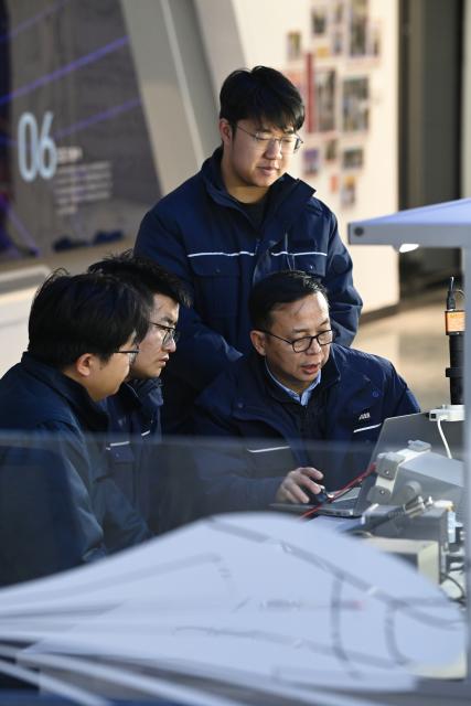 (260227) -- XI'AN, Feb. 27, 2026 (Xinhua) -- Dong Hongtao (front, R) communicates with members of a state-level master technician studio led by him in Xi'an, northwest China's Shaanxi Province, Jan. 14, 2026.
  Dong Hongtao is a bullet train technician of China Railway Xi'an Group Co., Ltd. and a deputy to the National People's Congress (NPC). Since engaging in electric multiple unit (EMU) maintenance work in 2007, Dong has led his team to maintain over 120,000 EMU sets and handled more than 3,000 faults. He has been granted three national invention patents and 31 utility model patents. Dong has also been dedicated to the passing-on of technical skills, cultivating skilled talents for the industry through the national-level master technician studio led by him.
   As a senior technician who started as an ordinary worker, Dong understands the challenges faced by frontline workers in their developments. He has observed that they often have abundant practical experiences but lack theoretical knowledge. In response, he actively participates in initiatives to improve their skills and identifies young talents to foster their creativity.
   For this year's legislative session, Dong said he will continue to focus on the development of the skilled workforce, concentrating on advancing the implementation of the new professional title system, which features eight technical titles -- three more than the previous five-tier system. (Xinhua/Li Yibo)