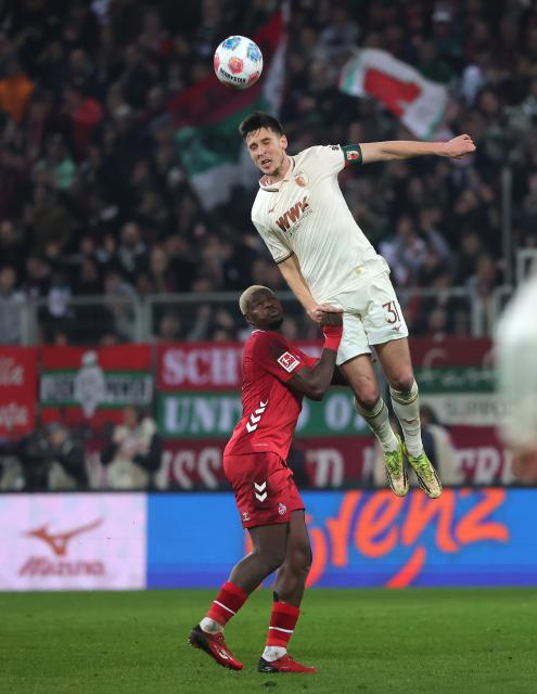 (260228) -- AUGSBURG, Feb. 28, 2026 (Xinhua) -- Keven Schlotterbeck (top) of FC Augsburg heads for the ball during the German first division Bundesliga football match between FC Augsburg and FC Cologne in Augsburg, Germany, Feb. 27, 2026. (Photo by Philippe Ruiz/Xinhua)
