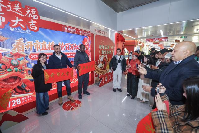 (260228) -- YIWU, Feb. 28, 2026 (Xinhua) -- Merchants pose for photos at the Global Digital Trade Center in Yiwu, east China's Zhejiang Province, Feb. 28, 2026. Merchants on Saturday kicked off the first business day of the Year of the Horse as the Yiwu International Trade City and the Global Digital Trade Center in Yiwu, the world's largest small-commodities hub, resumed operations after the Spring Festival holiday. According to local customs data, Yiwu's total foreign trade reached 836.5 billion yuan (about 121.97 billion U.S. dollars) in 2025, achieving an increase of 25.1 percent year on year. Exports rose more than 24 percent, and imports over 32 percent. (Xinhua/Xu Yu)