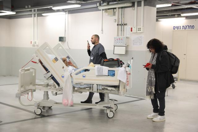 (260228) -- TEL AVIV, Feb. 28, 2026 (Xinhua) -- A medical personnel moves a patient in a parking lot at a medical center in Tel Aviv, Israel, Feb. 28, 2026. The alert level of all hospitals in Israel has been raised to the highest level after attacks in Iran, and hospitalized patients were transferred to shelters, the Israeli Health Ministry said in a statement. All non-urgent hospital activities have been canceled. (Gideon Markowicz/JINI via Xinhua)