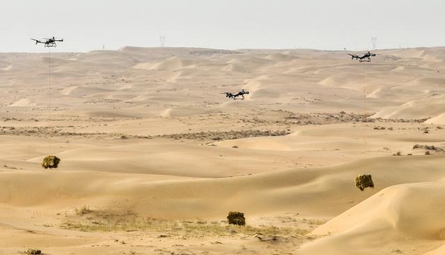 (260228) -- ALXA, Feb. 28, 2026 (Xinhua) -- An aerial drone photo shows drones carrying straws used to make straw checkerboard barriers for sand control at Ulan Buh Desert in Alxa League, north China's Inner Mongolia Autonomous Region, on Feb. 28, 2026.
  The Alxa league's sand prevention and control project of this year was launched on Saturday at Ulan Buh Desert, the eighth-largest in China. 
   Located in a key sand-control zone in northern China, Alxa League has implemented integrated sand-control measures combining engineering-based sand stabilization, biological treatment and ecosystems building. Over the past four decades, Alxa League has carried out sand prevention and control across nearly 100 million mu (6.67 million hectares) and will continue to contribute to building an ecological security barrier in northern China. (Xinhua/Bei He)