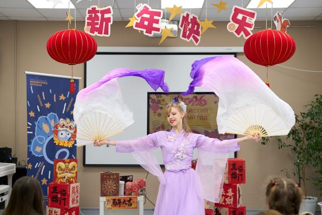 (260228) -- ST. PETERSBURG, Feb. 28, 2026 (Xinhua) -- A girl performs a traditional Chinese fan dance during an event at a library in St. Petersburg, Russia, Feb. 28, 2026. The event entitled "Traditional Chinese Culture in the Community" was hosted here on Saturday, where a local sinologist talked about culture and customs related to the Chinese Spring Festival. (Photo by Guo Feizhou /Xinhua)