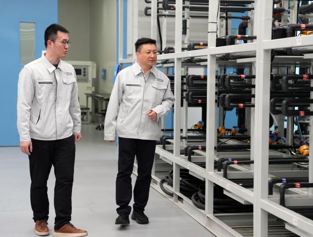 (260228) -- SHANGHAI, Feb. 28, 2026 (Xinhua) -- Zhang Fan (R) inspects a research base of China Electrical Equipment Group in Shanghai, east China, Jan. 27, 2026.
  Zhang Fan is vice general manager of China Electrical Equipment Group and a deputy to the National People's Congress (NPC). Zhang believes that "artificial intelligence (AI) plus manufacturing" would be achieved through strengthening top-level design and industry guidelines. Last year, Zhang presented a suggestion on deepening integration of manufacturing and AI to promote high-quality innovative development. His suggestion was given great importance. 
  In January 2026, eight departments of China including the Ministry of Industry and Information Technology jointly issued a plan which outlines an ambitious push to deeply integrate AI with the manufacturing sector, foster new quality productive forces and comprehensively empower new industrialization.
  Zhang stated that he will continue to concentrate on issues about the bottlenecks of data sharing in AI-driven manufacturing sector and successful experiences of leading enterprises. (Xinhua/Liu Ying)