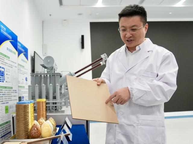 (260228) -- SHANGHAI, Feb. 28, 2026 (Xinhua) -- Zhang Fan introduces insulating cardboard, a key material for ultra-high voltage transformers, at a research base of China Electrical Equipment Group in Shanghai, east China, Jan. 27, 2026. Raw materials for insulating paperboard have been monopolized by foreign giants for a long time. Zhang led a team utilizing AI technology to advance domestic substitution, overcoming critical bottlenecks.
  Zhang Fan is vice general manager of China Electrical Equipment Group and a deputy to the National People's Congress (NPC). Zhang believes that "artificial intelligence (AI) plus manufacturing" would be achieved through strengthening top-level design and industry guidelines. Last year, Zhang presented a suggestion on deepening integration of manufacturing and AI to promote high-quality innovative development. His suggestion was given great importance. 
  In January 2026, eight departments of China including the Ministry of Industry and Information Technology jointly issued a plan which outlines an ambitious push to deeply integrate AI with the manufacturing sector, foster new quality productive forces and comprehensively empower new industrialization.
  Zhang stated that he will continue to concentrate on issues about the bottlenecks of data sharing in AI-driven manufacturing sector and successful experiences of leading enterprises. (Xinhua/Liu Ying)