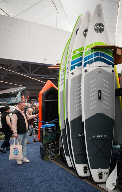 (260301) -- VANCOUVER, March 1, 2026 (Xinhua) -- A man looks at paddle boards at the 2026 Outdoor Adventure and Travel Show in Vancouver, British Columbia, Canada, on Feb. 28, 2026. The two-day annual event kicked off Saturday, with over 250 exhibitors showcasing the latest developments in camping gear, paddle sports equipment, outdoor clothing, scuba diving gear, and adventure travel experiences. (Photo by Liang Sen/Xinhua)