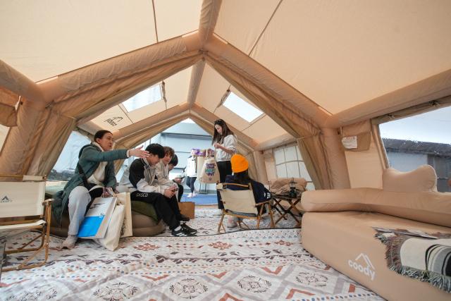 (260301) -- VANCOUVER, March 1, 2026 (Xinhua) -- Visitors experience an inflatable camping tent at the 2026 Outdoor Adventure and Travel Show in Vancouver, British Columbia, Canada, on Feb. 28, 2026. The two-day annual event kicked off Saturday, with over 250 exhibitors showcasing the latest developments in camping gear, paddle sports equipment, outdoor clothing, scuba diving gear, and adventure travel experiences. (Photo by Liang Sen/Xinhua)