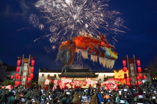 (260301) -- BEIJING, MARCH 1, 2026 (Xinhua) -- People watch an Ao Fish lantern parade at the Tangmo ancient town in Huangshan City, east China's Anhui Province, Feb. 27, 2026. The lantern parade was held here in celebration of the upcoming Lantern Festival on Friday, featuring the Ao Fish, a mythical Chinese creature with a dragon's head and a fish's body. (Xinhua/Du Yu)