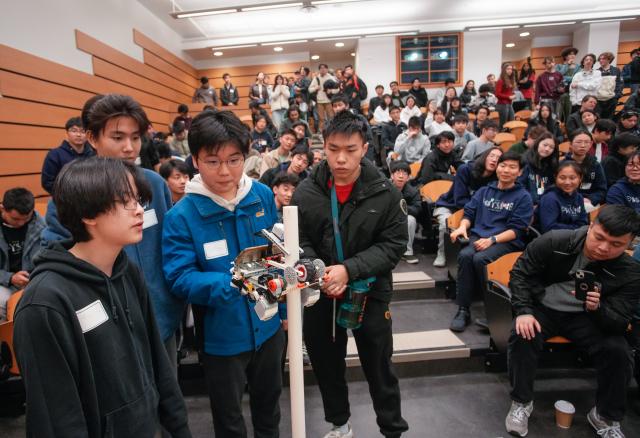 (260301) -- VANCOUVER, March 1, 2026 (Xinhua) -- Students look at a robotic pole climber in action during the 48th annual Physics Olympics at the University of British Columbia in Vancouver, British Columbia, Canada, on Feb. 28, 2026. More than 1,000 high school students from across the Canadian province of British Columbia participated in the 48th annual Physics Olympics held here on Saturday. (Photo by Liang Sen/Xinhua)