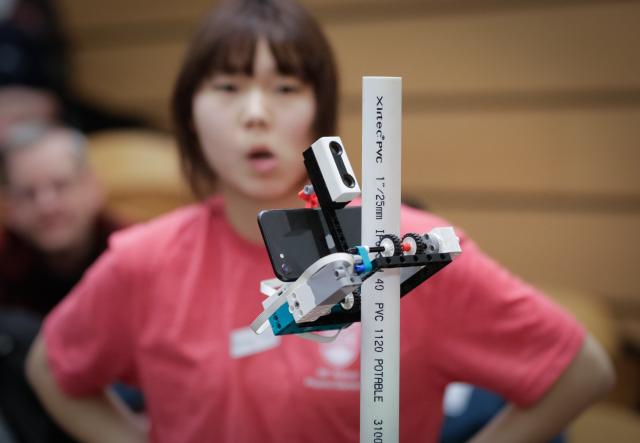 (260301) -- VANCOUVER, March 1, 2026 (Xinhua) -- A student looks at a robotic pole climber in action during the 48th annual Physics Olympics at the University of British Columbia in Vancouver, British Columbia, Canada, on Feb. 28, 2026. More than 1,000 high school students from across the Canadian province of British Columbia participated in the 48th annual Physics Olympics held here on Saturday. (Photo by Liang Sen/Xinhua)