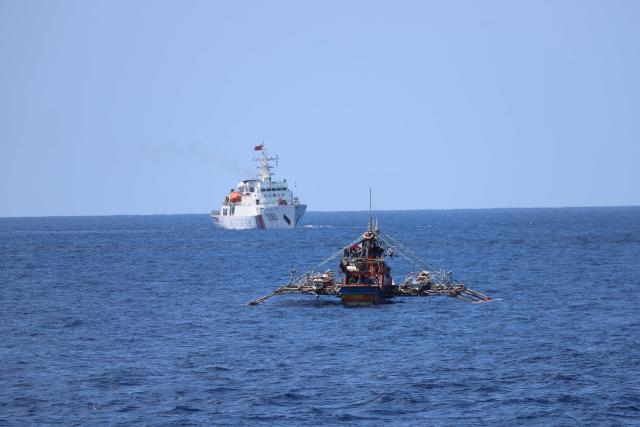 (260301) -- SOUTH CHINA SEA, March 1, 2026 (Xinhua) -- China Coast Guard (CCG) vessel Hailing lawfully expels a Philippine fishing boat in waters off China's Huangyan Dao in the South China Sea, Feb. 27, 2026. The CCG on Friday drove away Philippine vessels that illegally intruded into China's territorial waters off Huangyan Dao in the South China Sea. (CCG/Handout via Xinhua)