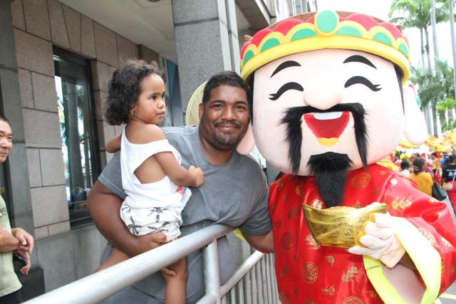 (260301) -- PORT LOUIS, March 1, 2026 (Xinhua) -- Spectators pose for photos with a performer taking part in a float parade marking the Spring Festival in Port Louis, Mauritius, Feb. 28, 2026. The parade, jointly organized by the Chinese Embassy in Mauritius, the China Cultural Center in Mauritius, the Municipality of Port Louis and the United Chinese Associations, was held in a festive and sharing atmosphere in Port Louis on Saturday. (Photo by Ally Soobye/Xinhua)
