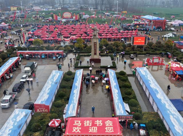 (260301) -- BAOFENG, March 1, 2026 (Xinhua) -- An aerial drone photo shows a view at the Majie Quyi Fair at Majie Village of Baofeng County, central China's Henan Province, March 1, 2026.
  The annual Majie Quyi Fair, a grand feast for Quyi fans, was staged as scheduled here on Sunday, as part of the ongoing Chinese New Year celebrations. 
   Quyi refers to a school of traditional Chinese folk arts in narrative and singing forms, including ballad singing, comic dialogues, clapper talk and crosstalk, still popular among the Chinese people.
    The Majie Quyi Fair, well attended despite the bad weather, boasts a history of over 700 years, and was inscribed in the first national intangible cultural heritage list in 2006. (Xinhua/Li Jianan)
