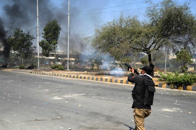 (260301) -- KARACHI, March 1, 2026 (Xinhua) -- A policeman fires teargas canisters at protesters during clashes near U.S. Consulate in southern Pakistani port city of Karachi on March 1, 2026. At least nine people were killed and more than 12 others injured on Sunday as angry protesters clashed with law enforcement personnel outside the U.S. Consulate in Karachi in the southern Sindh province, rescue officials said. 
   The clashes erupted when demonstrators tried to enter the consulate premises, prompting security forces to respond, according to Rescue 1122 Sindh. (Photo by Imran Ali/Xinhua)